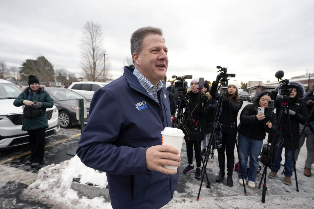 New Hampshire Gov. Chris Sununu walks past members of the media while greeting people in Hampton, N.H. 