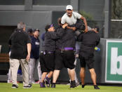 Fiueld guards carry away one of two fans who approached Atlanta Braves right fielder Ronald Acuna Jr. as Acuna took the field for the bottom of the seventh inning of a baseball game against the Colorado Rockies, Monday, Aug. 28, 2023, in Denver. (AP Photo/David Zalubowski)