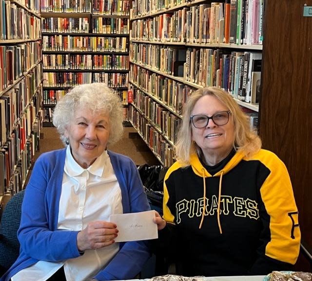 Judy Kindle, president of the Ellwood City Area Public Library Board (left), receives a $1,000 check from Lynn Campbell of the Riverside Lions Club from the club's basket raffle fundraiser.