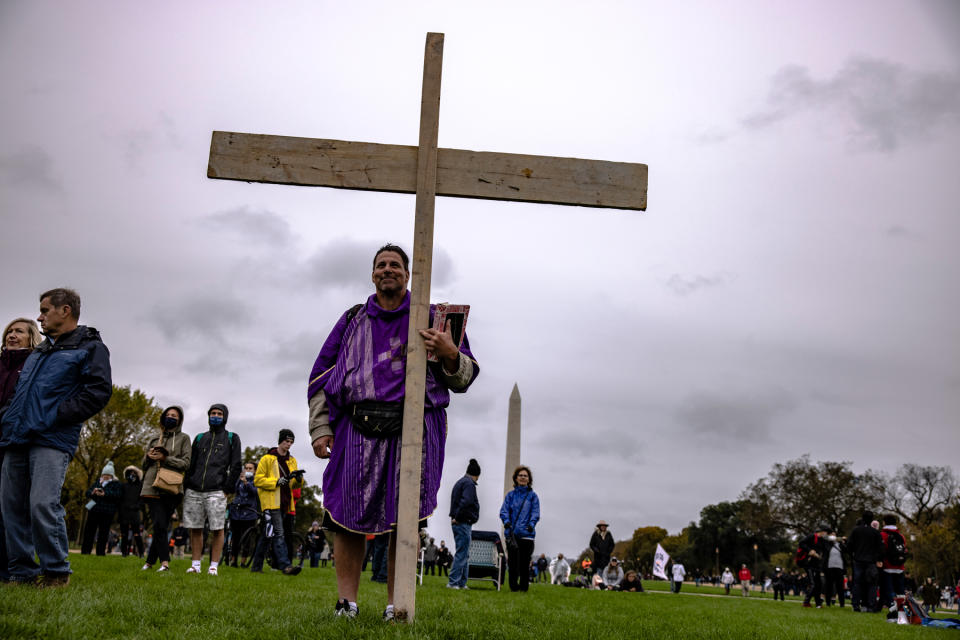 A man carries a large wooden cross during a concert by evangelical musician Sean Feucht on the National Mall on Oct. 25, 2020, in Washington, DC. - Credit: Samuel Corum/Getty Images
