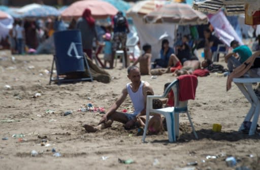 A man sits on the beach in Rabat on July 12, 2018