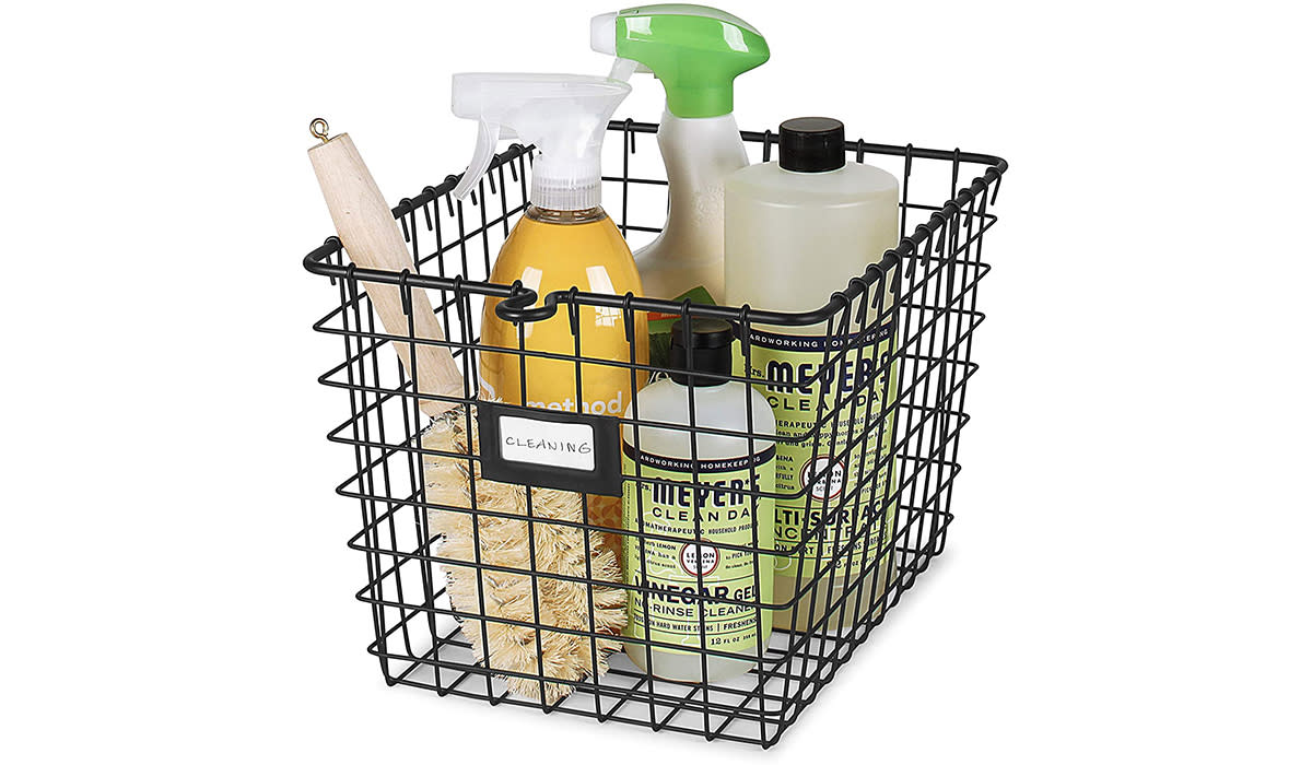 Black wire basket holding cleaning supplies