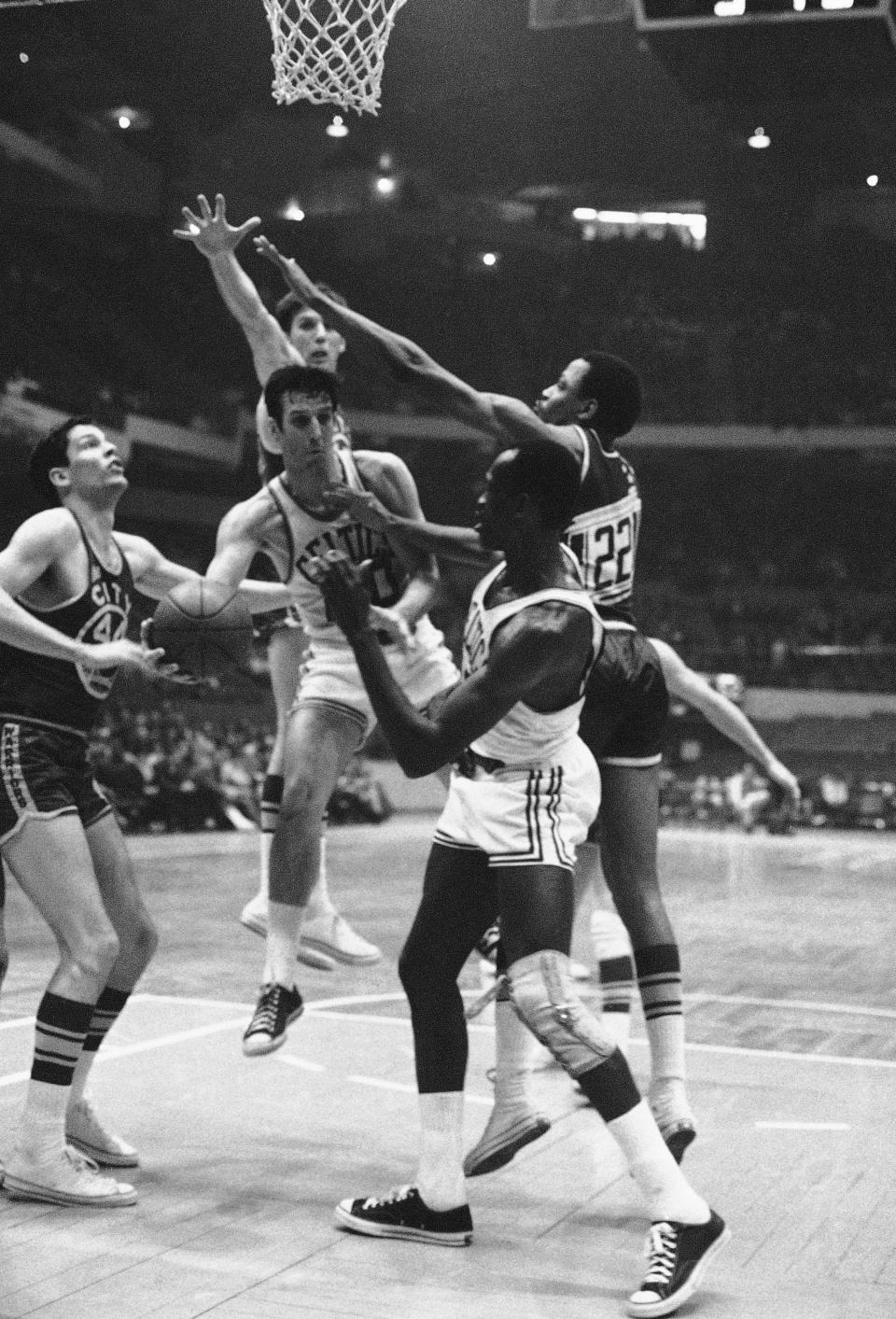 Larry Siegfried of the Boston Celtics comes up with a rebound in a game against the San Francisco Warriors at Boston Garden on Wednesday, Feb. 29, 1968. The other players are Fred Hetzel (44), Bill Turner (22), both of the Warriors, and Tom Sanders of the Celtics.