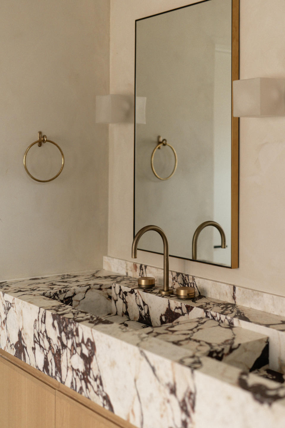 A bathroom vanity lit by two wall lights