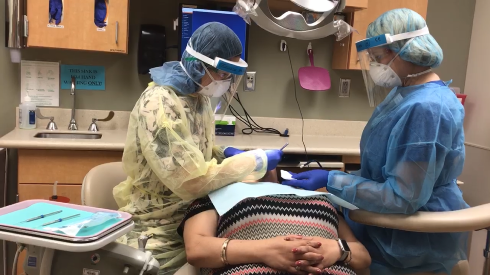 Dr. Linda Rasubala and Dental Assistant Olga Kushch treat a patient in Eastman Dental’s Howitt Urgent Dental Care clinic.