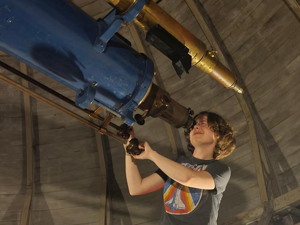 Gillis Lowry takes a look through a telescope inside Fuertes observatory.