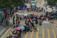 In this Saturday, May 1, 2021, photo, domestic helpers from the Philippines line up at the temporary testing center for COVID-19, in Hong Kong. Hong Kong officials have dropped a plan to make it mandatory for foreign domestic workers to be vaccinated against the coronavirus, after the move drew criticism that it was discriminatory. (AP Photo/Kin Cheung)