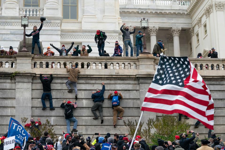 Rioters scale a wall at the U.S. Capitol on Jan. 6, 2021.