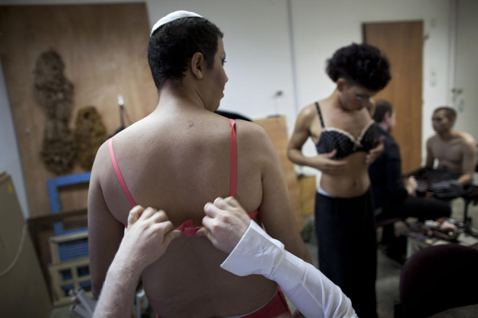 In this photo taken on Tuesday, June 18, 2013, Israeli Orthodox Jew Shahar Hadar gets dressed as he prepares for a show at a drag queen school in downtown Tel Aviv, Israel. Hadar, a telemarketer by day, has taken the gay Orthodox struggle from the synagogue to the stage, beginning to perform as one of Israel’s few religious drag queens. His drag persona is that of a rebbetzin, a female rabbinic advisor, a wholesome guise that stands out among the sarcastic and raunchy cast of characters on Israel’s drag queen circuit. (AP Photo/Oded Balilty)