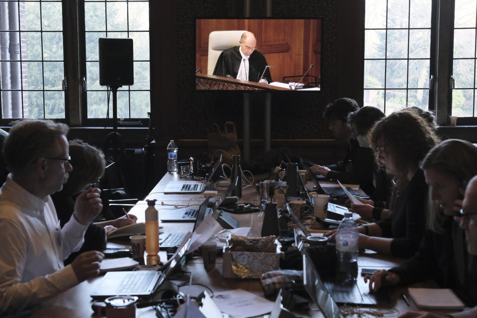 Journalists watch a video screen in a room outside the courtroom during the opening of the hearings at the International Court of Justice in The Hague, Netherlands, Thursday, Jan. 11, 2024. The United Nations' top court opens hearings Thursday into South Africa's allegation that Israel's war with Hamas amounts to genocide against Palestinians, a claim that Israel strongly denies. (AP Photo/Patrick Post)