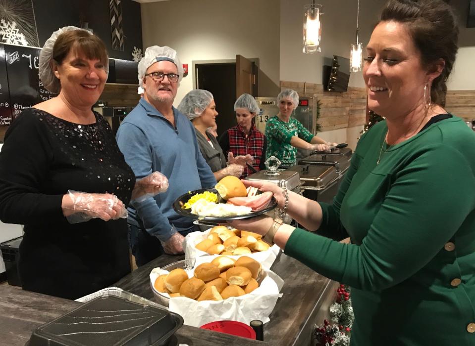 Young Life Green Bay volunteer Chelsea Faase, right, prepares to take a ham dinner to a guest at the Four Winds Free Community Christmas Dinner on Dec. 25, 2019, in Green Bay.