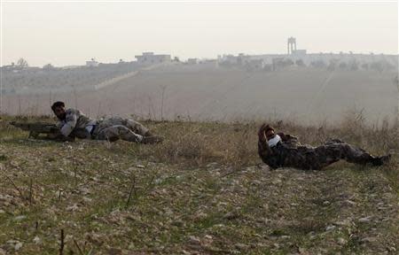 Free Syrian Army fighters crawl during clashes with forces loyal to Syria's President Bashar al-Assad in the town of Souran in the north Hama countryside February 16, 2014. REUTERS/Stringer