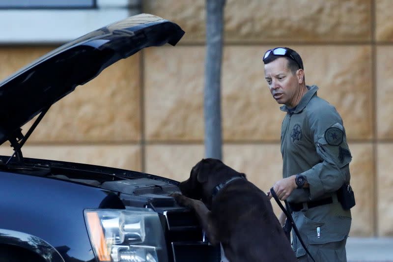 A k9 unit inspects a car at the University of California Irvine Medical Center where former U.S. President Bill Clinton was admitted in Orange