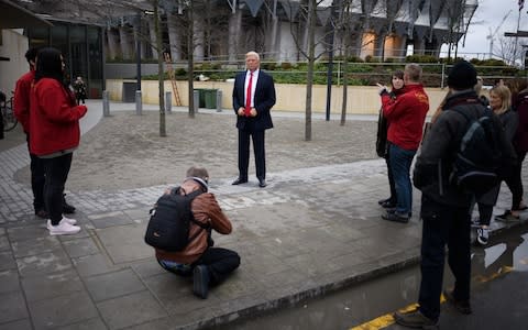 People take photographs of a model of US President Donald Trump - Credit: Getty 