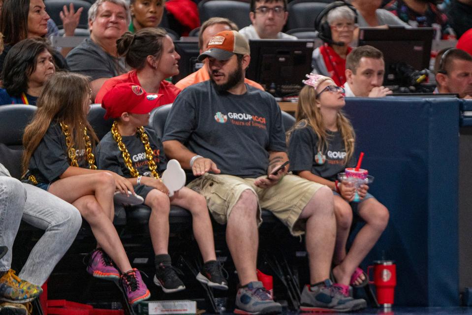 Guests of Group1001, Ava, Eli, Dusten and Megan Krost sit on the sideline on Sunday June 16, 2024, during the game at Gainbridge Fieldhouse in Indianapolis. Eli was in a viral video clip of him attempting a shot on Indiana Fever guard Caitlin Clark (22) during a community event.