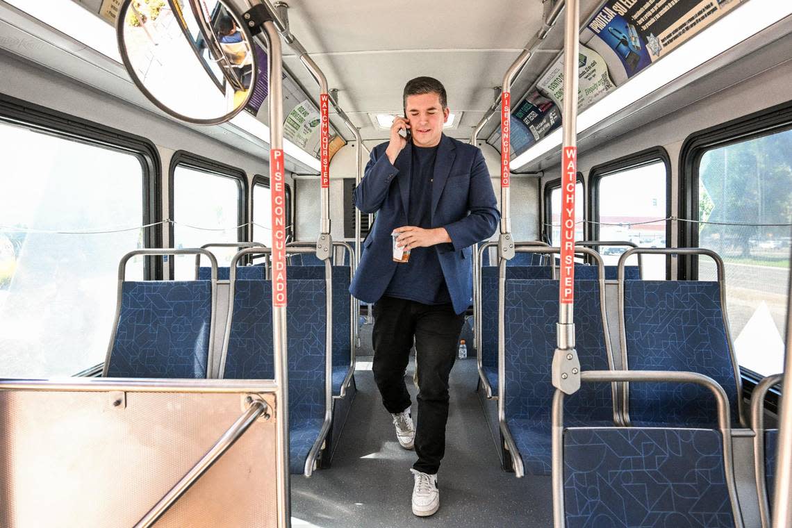 Fresno City Councilmember Tyler Maxwell talks on his phone while preparing to get off a Fresno FAX bus after taking a ride through town on Tuesday, Aug. 15, 2023.