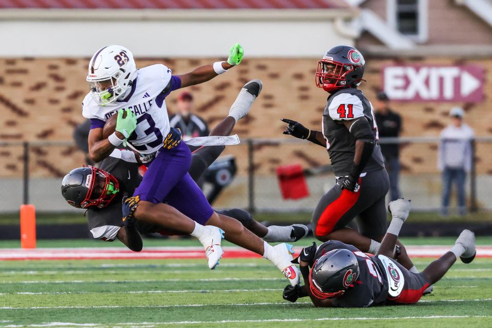 Central Catholic Fighting Irish defensive back Marvon Greenlee, left, finds success on a third attempt to tackle Warren De La Salle Pilots wide receiver Phoenix Glassnor in a Catholic High School League football game at Gallagher Stadium on Sept. 15, 2023 in Toledo.