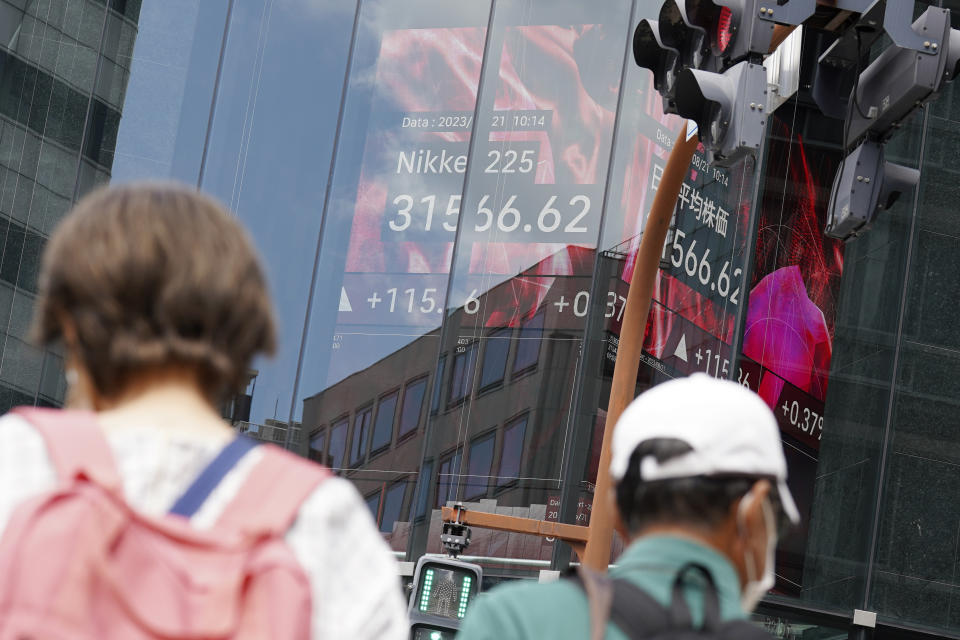 People stand in front of an electronic stock board showing Japan's Nikkei 225 index at a securities firm Monday, Aug. 21, 2023, in Tokyo. Asian stocks were mixed Monday as traders looked ahead to the Federal Reserve’s summer conference for signs of whether the U.S. central bank thinks inflation is under control or more interest rate hikes are needed to cool inflation. (AP Photo/Eugene Hoshiko)