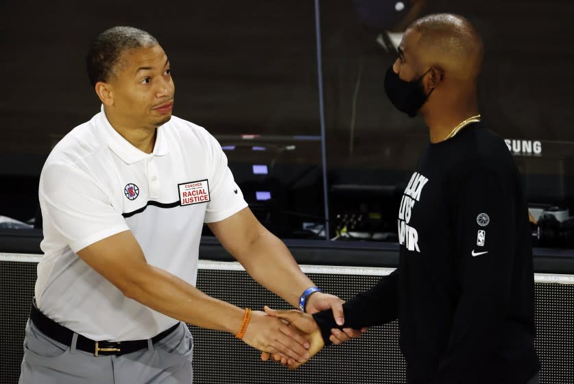 Los Angeles Clippers assistant coach Tyronn Lue, left, shakes hands with Oklahoma City Thunder's Chris Paul during the first quarter of an NBA basketball game Friday, Aug. 14, 2020, in Lake Buena Vista, Fla. (Mike Ehrmann/Pool Photo via AP)