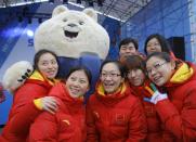 Members of the Chinese Olympic team pose with an Olympic mascot after a welcoming ceremony before the 2014 Winter Olympics, Wednesday, Feb. 5, 2014, in Sochi, Russia. (AP Photo/Vadim Ghirda)