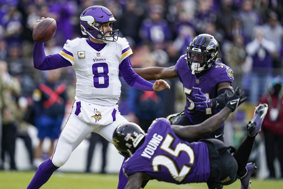 Minnesota Vikings quarterback Kirk Cousins (8) throws under pressure from Baltimore Ravens cornerback Tavon Young (25) and outside linebacker Tyus Bowser (54) during the second half of an NFL football game, Sunday, Nov. 7, 2021, in Baltimore. (AP Photo/Julio Cortez)