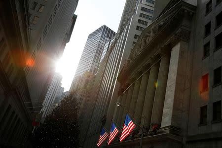 U.S. flags hang at the New York Stock Exchange in Manhattan, New York City, U.S., December 21, 2016. REUTERS/Andrew Kelly