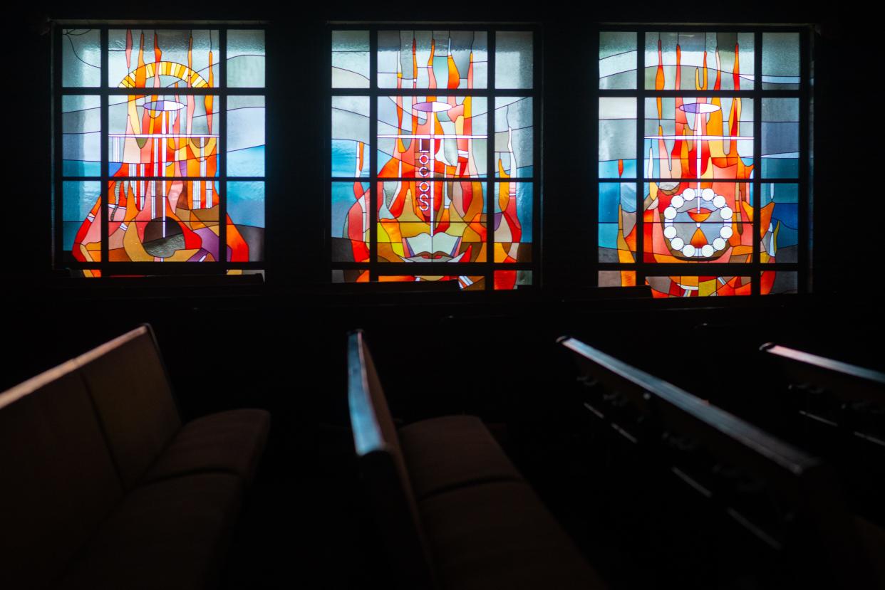 A triptych of stained-glass windows on the north side of Lowman Methodist Church sanctuary feature mid-20th century designs by artist Robert Harmon, of Arcadia, Missouri. Each part of the panels represent aspects of the Methodist religion with the center panel featuring an open Bible with the Greek word "logos" which translates to the Word of God.