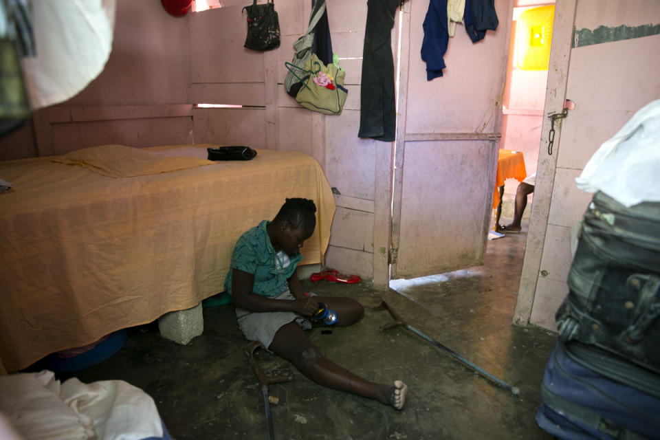 Rose-Berline Thomas, de 12 años, arregla una lámpara en su modesta vivienda de Canaan, Haití, el 3 de enero del 2020. La niña, una de siete hermanos, perdió parte de una pierna en el terremoto de hace diez años y tiene dificultades para movilizarse por falta de atención médica. Pero es quien maneja su casa, mientras sus padres trabajan. (AP Photo/Dieu Nalio Chery)