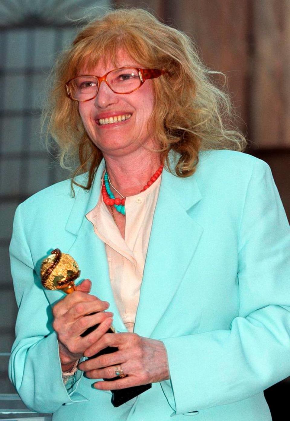 La actriz italiana Monica Vitti sostiene el Globo de Oro por su carrera que acaba de recibir durante una ceremonia en los estudios de cine Cinecittà de Roma, el 24 de junio de 2000.  (Foto AP/Marco Ravagli, archivo)