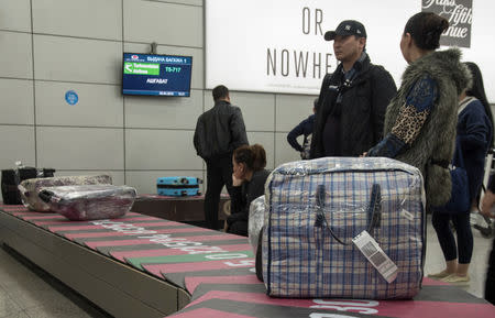 FILE PHOTO: People, including passengers of a flight from the Turkmen capital Ashgabat, gather in the baggage claim area upon their arrival at Almaty International Airport, Kazakhstan April 5, 2019. REUTERS/Mariya Gordeyeva