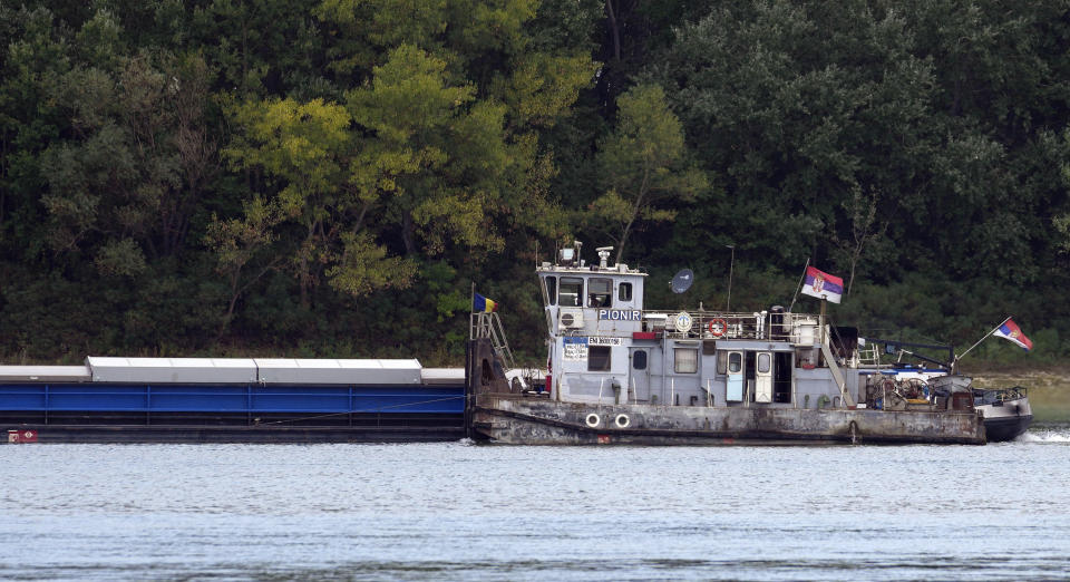 A boat on the Danube river passes by the wreckage of a WWII German warships near Prahovo, Serbia, Monday, Aug. 29, 2022. The worst drought in Europe in decades has not only scorched farmland and hampered river traffic, it also has exposed a part of World War II history that had almost been forgotten. The hulks of dozens of German battleships have emerged from the mighty Danube River as its water levels dropped. (AP Photo/Darko Vojinovic)