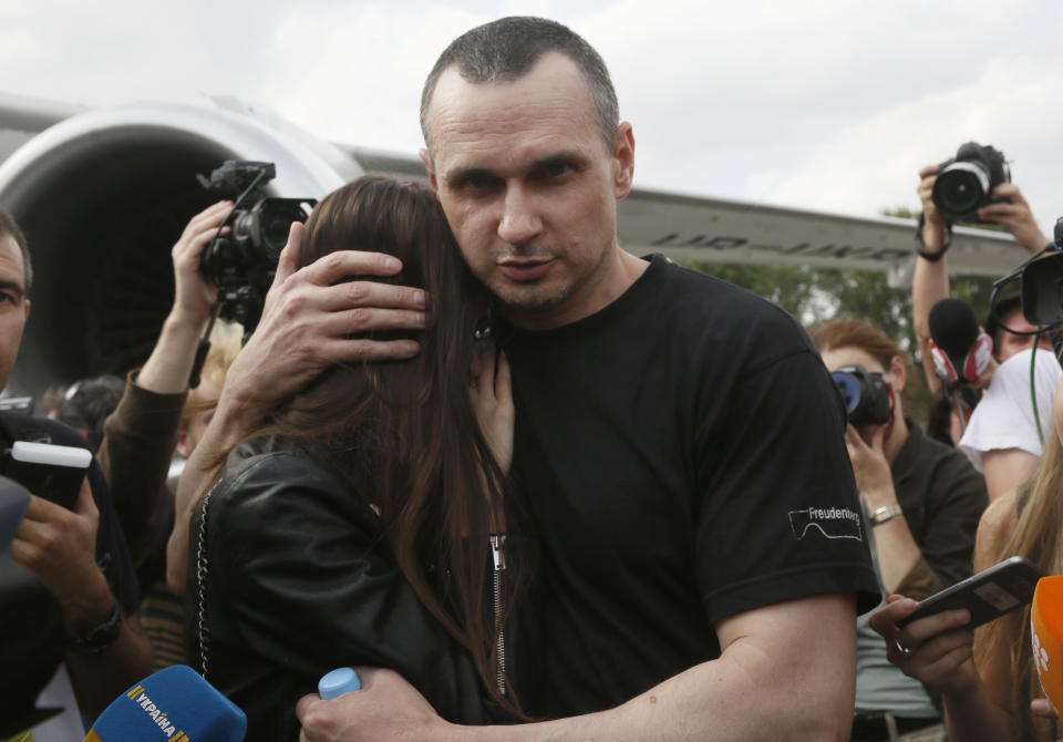 Ukrainian filmmaker Oleg Sentsov hugs his daughter upon his arrival at Boryspil airport, outside Kyiv, Ukraine, Saturday, Sept. 7, 2019. Planes carrying prisoners freed by Russia and Ukraine have landed in the countries' capitals, in an exchange that could be a significant step toward improving relations between Moscow and Kyiv. The planes, each reportedly carrying 35 prisoners, landed almost simultaneously at Vnukovo airport in Moscow and at Kyiv's Boryspil airport. (AP Photo/Efrem Lukatsky)