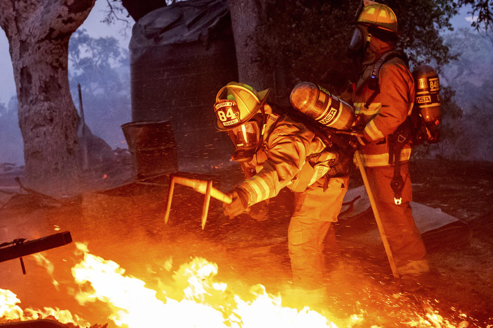Firefighters extinguish a burning outbuilding as the Point Fire spreads along West Dry Creek Road in Healdsburg, Calif., on Sunday, June 16, 2024. (AP Photo/Noah Berger)
