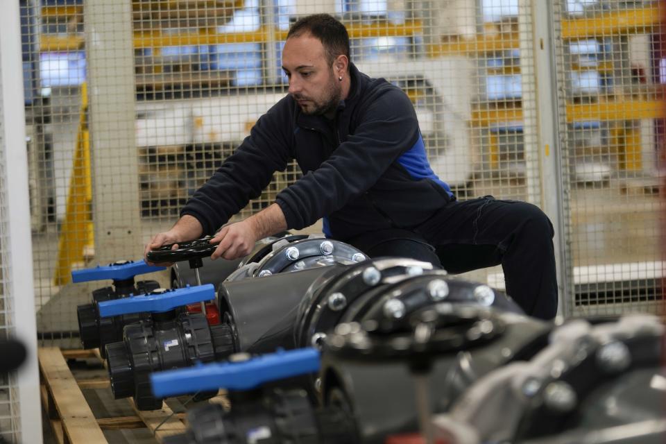 A worker fixes pool water pipes at the Myrtha Pools factory, in Castiglione delle Stiviere, northern Italy, Tuesday, March 12, 2024. Italian company Myrtha Pools is producing 24 pools for the Paris Olympics at its factory in Castiglione delle Stiviere, near Verona. The pools will be used for swimming, diving, water polo, artistic swimming and training areas in Paris. It's the sixth Olympics that Myrtha will be providing pools for. (AP Photo/Luca Bruno)