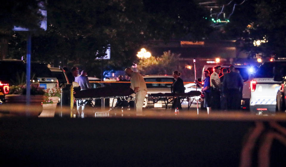 FILE - In this Aug. 4, 2019 file photo, bodies are removed from at the scene of a mass shooting in Dayton, Ohio. The FBI has labeled two of those attacks, at a Texas Walmart and California food festival, as domestic terrorism — acts meant to intimidate or coerce a civilian population and affect government policy. But the bureau hasn't gone that far with the shooting at the Ohio entertainment district. (AP Photo/John Minchillo, File)