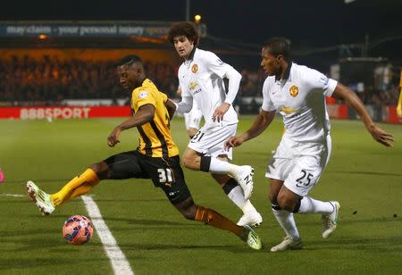 Manchester United's Antonio Valencia (R) and Marouane Fellaini (C) challenge Cambridge United's Sullay Kaikai during their English FA Cup 4th round soccer match at The Abbey Stadium in Cambridge, eastern England January 23, 2015. REUTERS/Andrew Winning