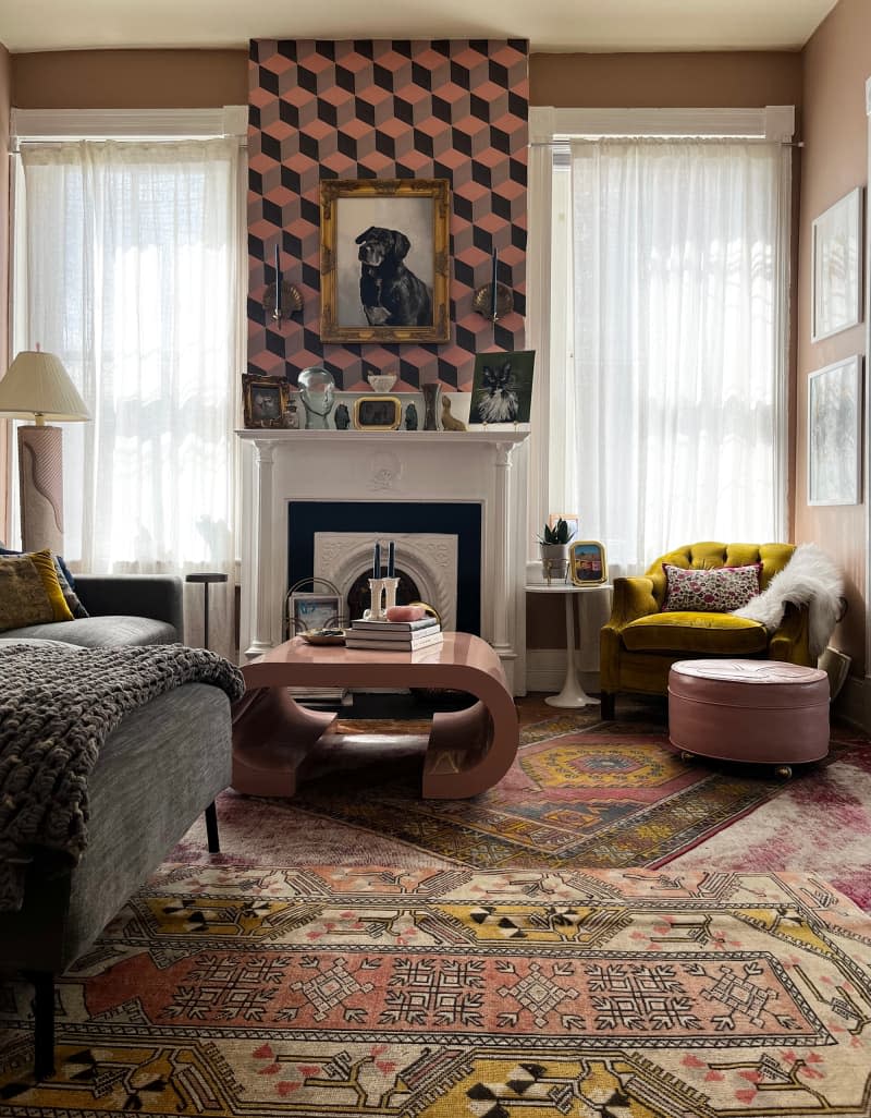 View of pink living room with multiple patterned area rugs.