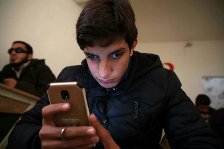 A student at an association for the blind in Syria's Aleppo province learns to navigate his smartphone using a screen reader app