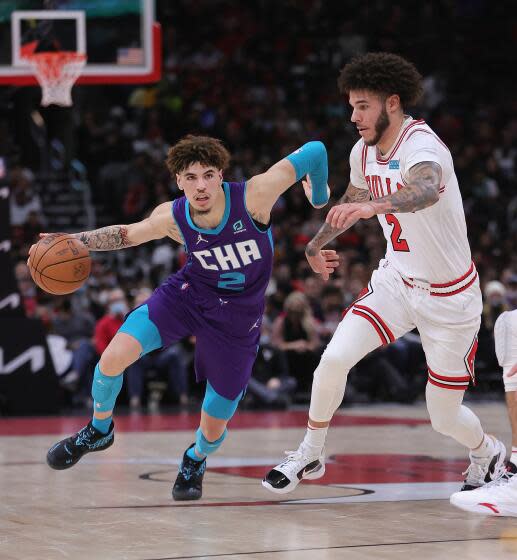 Hornets guard LaMelo Ball, left, drives against Bulls guard Lonzo Ball during a game.