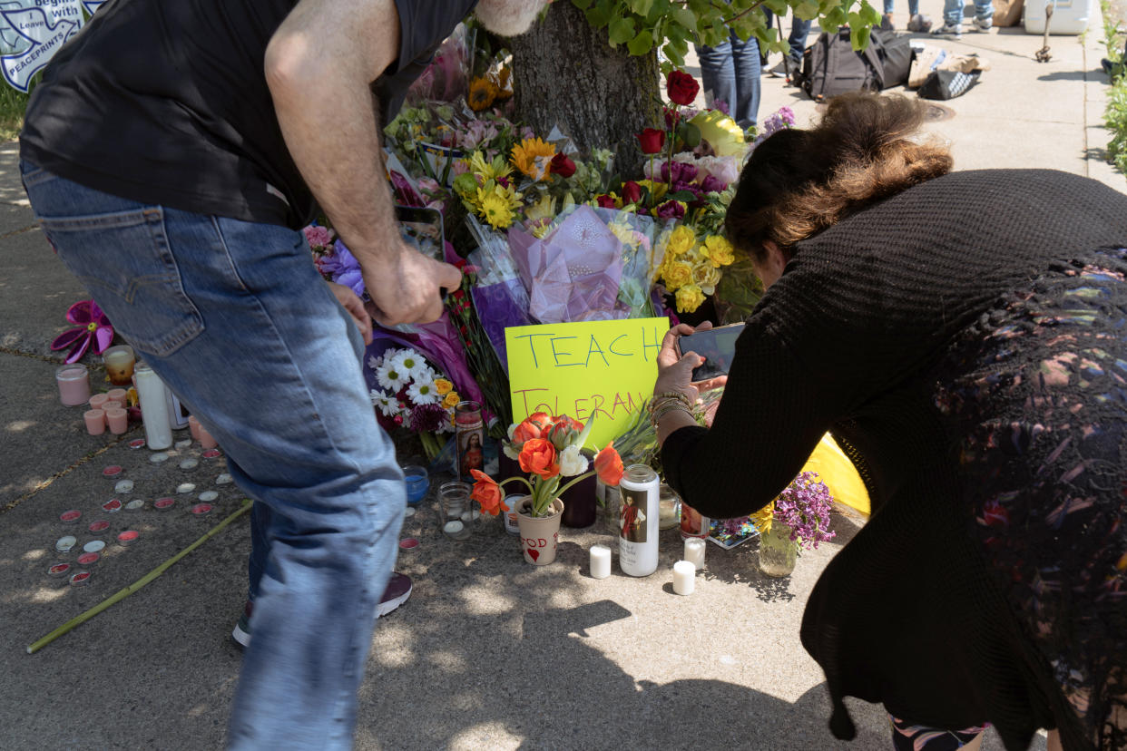 People visit a memorial on Sunday across the street from the Tops supermarket where a shooter killed 10 people and injured 3 others in Buffalo, N.Y. (Joshua Thermidor for NBC News)
