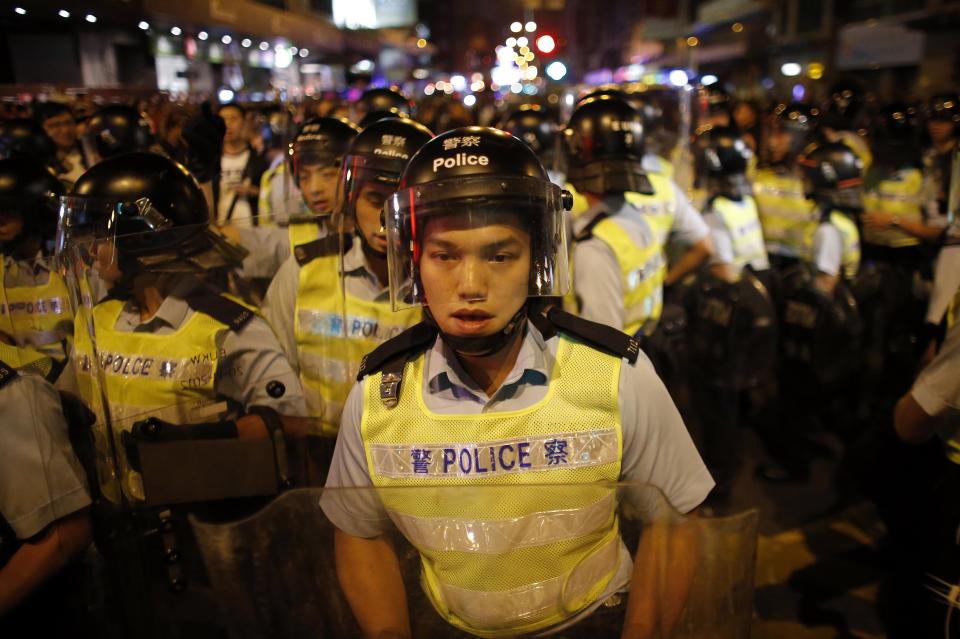 Riot polices arrive at a protest site during clashes with pro-democracy protesters at the Mongkok shopping district of Hong Kong October 19, 2014. Hong Kong pro-democracy activists recaptured parts of a core protest zone from police early on Saturday after hours of turmoil that the city's police chief warned undermined order and jeopardised public safety. REUTERS/Carlos Barria (CHINA - Tags: CIVIL UNREST POLITICS)