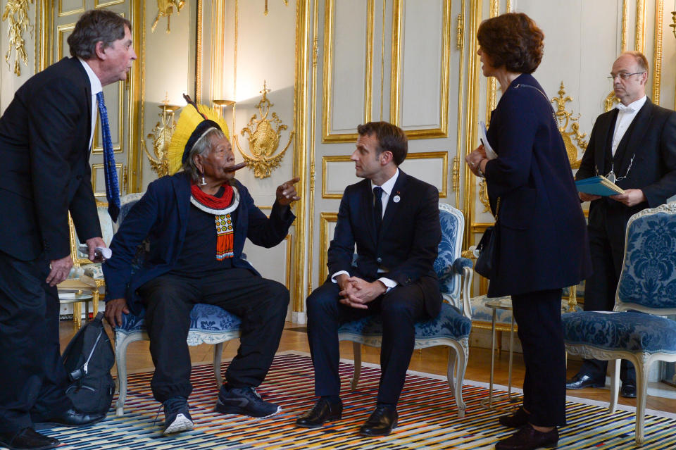 FILE - France's President Emmanuel Macron, second from right, meets with Kayapo Indigenous leader Raoni Metuktire, sitting, and Belgium filmmaker Jean-Pierre Dutilleux, far left, at the Elysee Palace in Paris, France, May 16, 2019. For five decades, the Amazonian tribal chief and Belgium filmmaker enlisted presidents and royals to improve the lives of Brazil’s Indigenous peoples and protect their lands. (SIPA/Pool via AP, File)