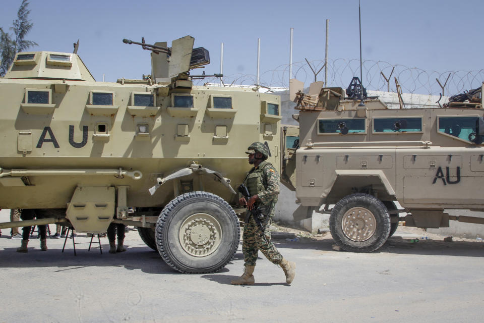 An African Union peacekeeper from Uganda provides security as Somali lawmakers arrive to cast their vote in the presidential election, at the Halane military camp in Mogadishu, Somalia Sunday, May 15, 2022. Legislators in Somalia are meeting Sunday to elect the country's president in the capital, Mogadishu, which is under lockdown measures aimed at preventing deadly militant attacks. (AP Photo/Farah Abdi Warsameh)