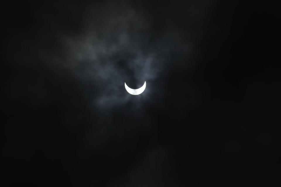 The sun is seen through rain clouds during solar eclipse in Ahmedabad, India, Sunday, June 21, 2020. (AP Photo/Ajit Solanki)