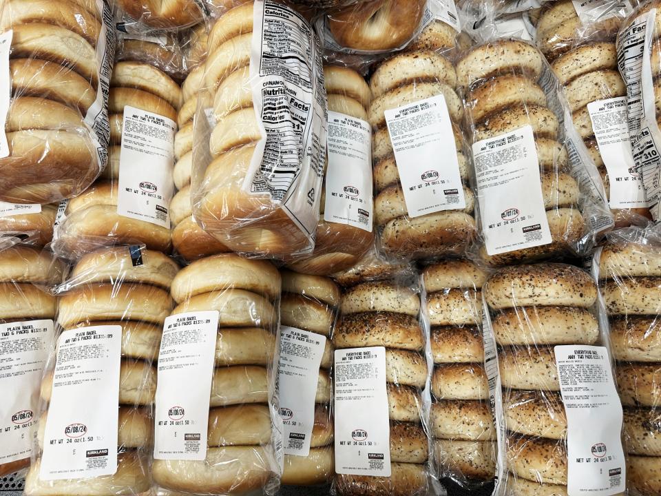 Bags of golden-brown plain and everything bagels in clear plastic bags at Costco