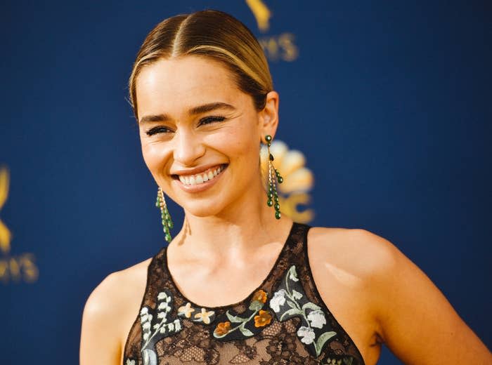 Emilia smiles in a sleeveless black lace dress