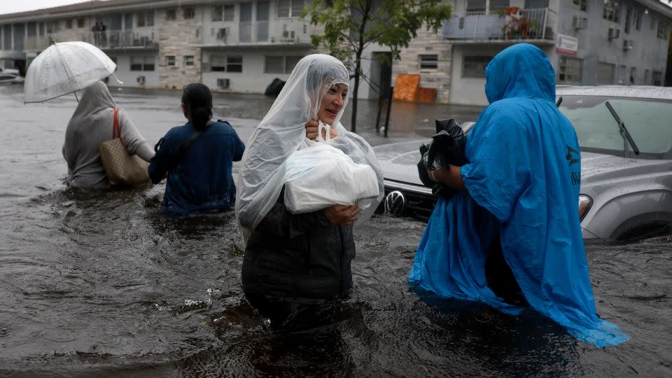 Residents walk through a flooded street in Hollywood, Florida, on Wednesday. - Joe Raedle/Getty Images