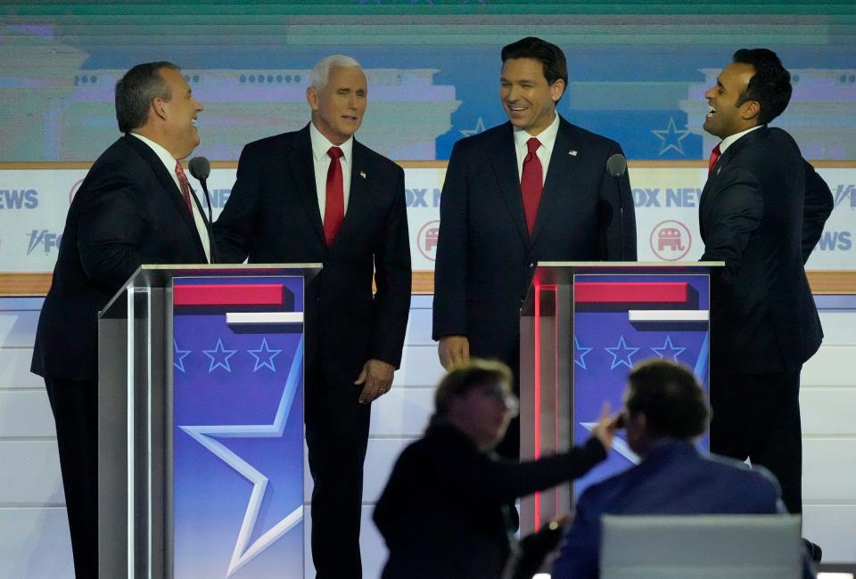 From left, former New Jersey Gov. Chris Christie, former Vice President Mike Pence, Florida Gov. Ron DeSantis and biotech entrepreneur Vivek Ramaswamy joke with one another during a commercial break at at the first Republican presidential debate on Aug. 23, 2023, in Milwaukee.