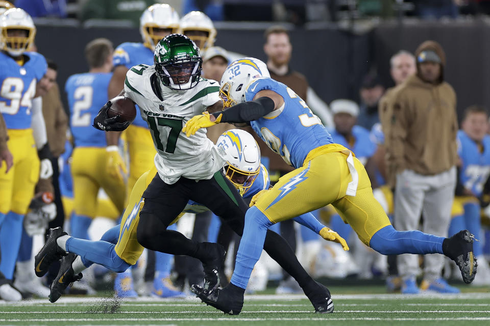 New York Jets wide receiver Garrett Wilson (17) tries to avoid a tackle by Los Angeles Chargers safety Alohi Gilman (32) during the first quarter an NFL football game, Monday, Nov. 6, 2023, in East Rutherford, N.J. (AP Photo/Adam Hunger)