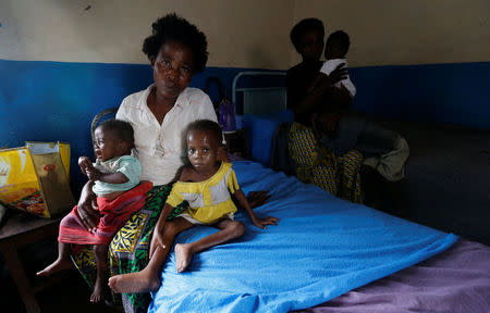 An internally displaced woman sits with her severely acute malnourished children as they wait to receive medical attention at the Tshiamala general referral hospital of Mwene Ditu in Kasai Oriental Province in the Democratic Republic of Congo, March 15, 2018. Picture taken March 15, 2018. REUTERS/Thomas Mukoya